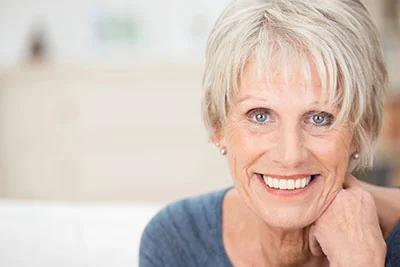 woman smiling big after getting same-day dental crowns