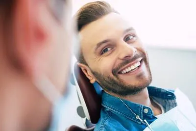 man discussing dental crown options during his visit to Penterson & Booth Family and Cosmetic Dentistry