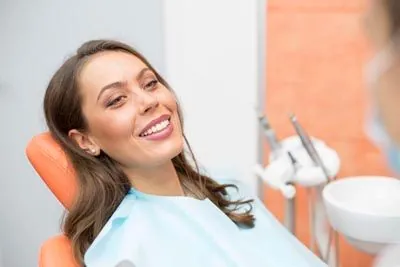 woman laying back in the dental chair while getting her teeth cleaned