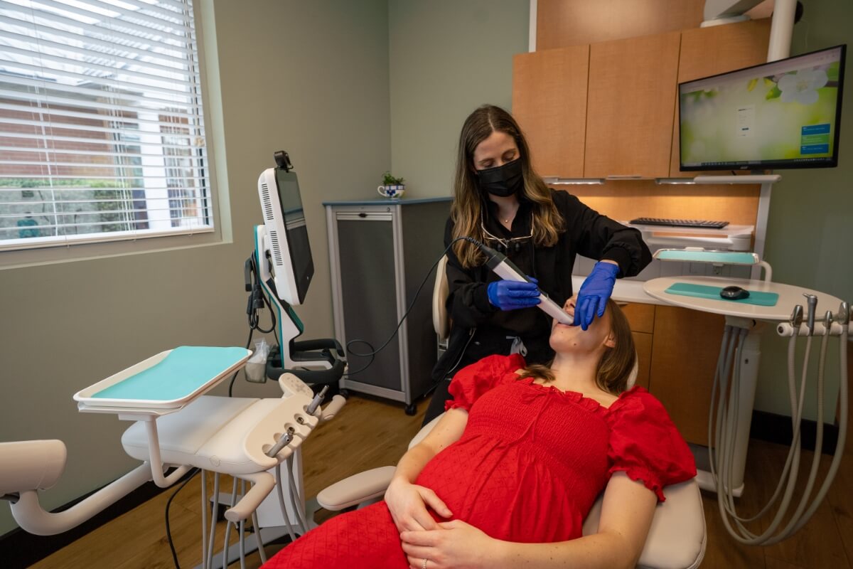 Dr. Lynn Booth working with a female patient sitting in dental chair