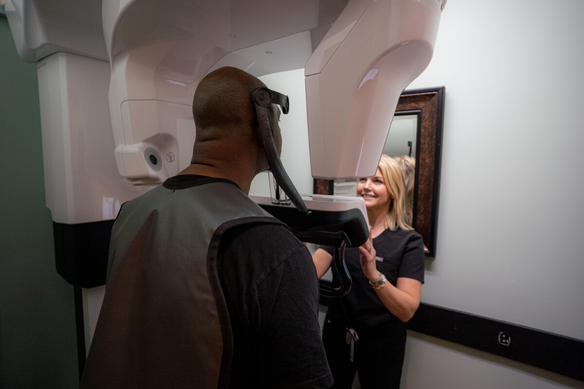 Dental assistant giving a restorative dentistry patient a CBCT Scan
