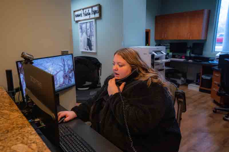 Front desk receptionist answering a patient phone call about sedation dentistry options